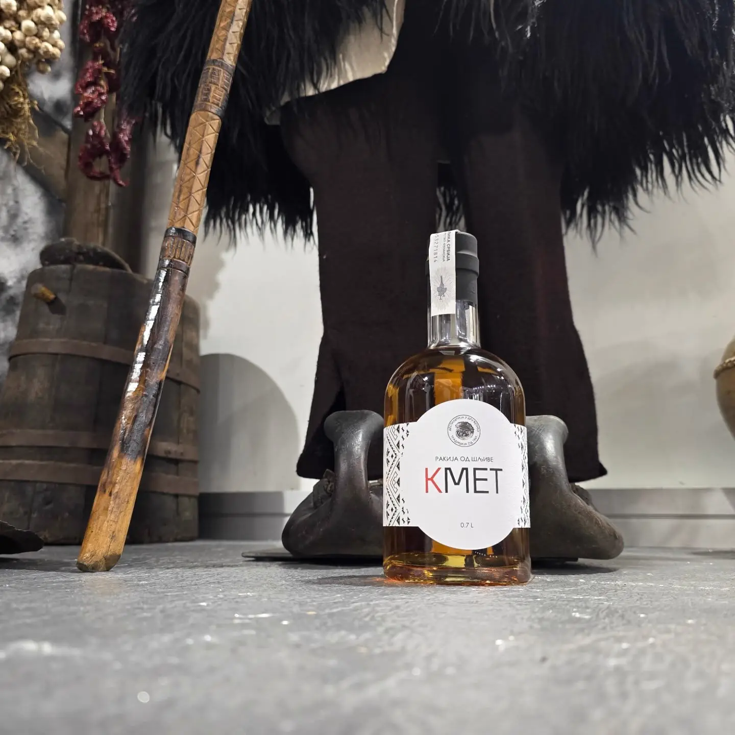 Steklenica žganja Kmet iz sliv ob tradicionalnih predmetih
