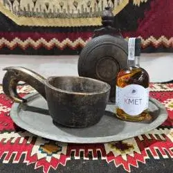 Steklenica žganja Kmet ob tradicionalni leseni čaši